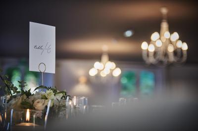 Un grand groupe de personnes souriantes levant les bras, rassemblées dans un parc pour une célébration.