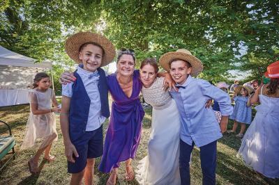 Un grand groupe de personnes souriantes levant les bras, rassemblées dans un parc pour une célébration.