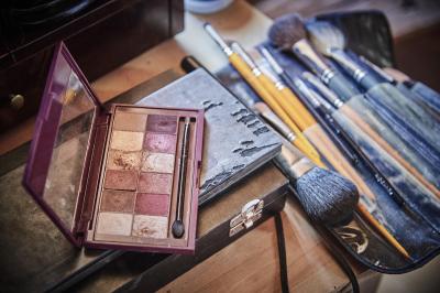 Un grand groupe de personnes souriantes levant les bras, rassemblées dans un parc pour une célébration.