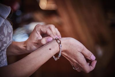 Un grand groupe de personnes souriantes levant les bras, rassemblées dans un parc pour une célébration.