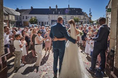 Un grand groupe de personnes souriantes levant les bras, rassemblées dans un parc pour une célébration.