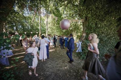 Un grand groupe de personnes souriantes levant les bras, rassemblées dans un parc pour une célébration.