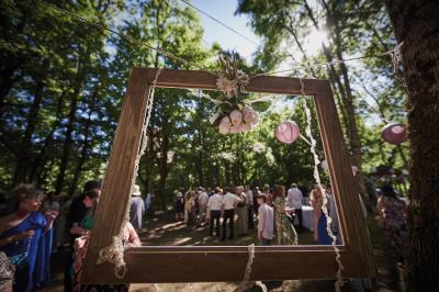 Un grand groupe de personnes souriantes levant les bras, rassemblées dans un parc pour une célébration.