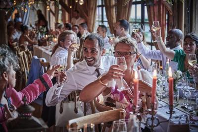 Un grand groupe de personnes souriantes levant les bras, rassemblées dans un parc pour une célébration.