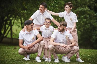 Un grand groupe de personnes souriantes levant les bras, rassemblées dans un parc pour une célébration.