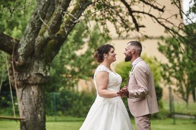 Un grand groupe de personnes souriantes levant les bras, rassemblées dans un parc pour une célébration.