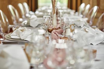 Un grand groupe de personnes souriantes levant les bras, rassemblées dans un parc pour une célébration.
