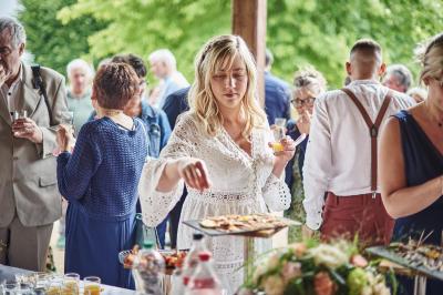 Un grand groupe de personnes souriantes levant les bras, rassemblées dans un parc pour une célébration.