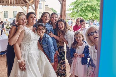 Un grand groupe de personnes souriantes levant les bras, rassemblées dans un parc pour une célébration.