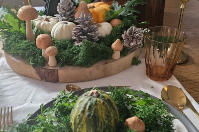 Présentoir en bois décoré de fleurs et de choux colorés, lors d'une célébration en extérieur.