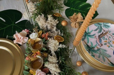 Présentoir en bois décoré de fleurs et de choux colorés, lors d'une célébration en extérieur.