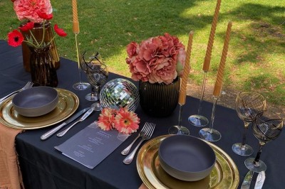 Présentoir en bois décoré de fleurs et de choux colorés, lors d'une célébration en extérieur.