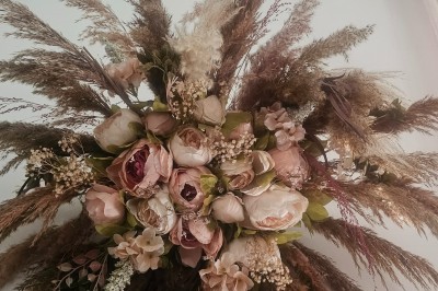 Présentoir en bois décoré de fleurs et de choux colorés, lors d'une célébration en extérieur.