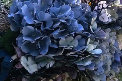 Présentoir en bois décoré de fleurs et de choux colorés, lors d'une célébration en extérieur.