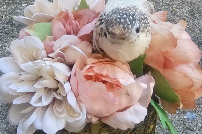 Présentoir en bois décoré de fleurs et de choux colorés, lors d'une célébration en extérieur.