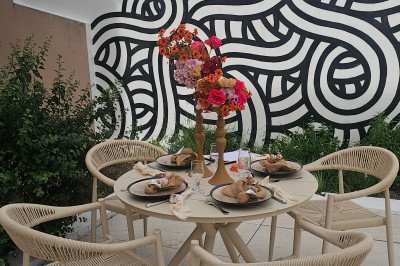 Présentoir en bois décoré de fleurs et de choux colorés, lors d'une célébration en extérieur.