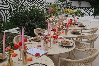 Présentoir en bois décoré de fleurs et de choux colorés, lors d'une célébration en extérieur.