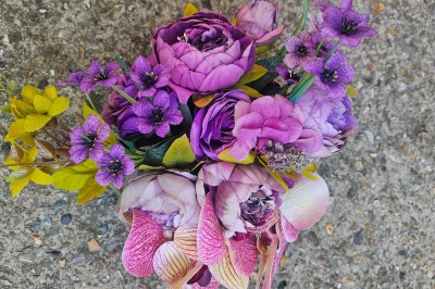 Présentoir en bois décoré de fleurs et de choux colorés, lors d'une célébration en extérieur.