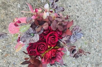 Présentoir en bois décoré de fleurs et de choux colorés, lors d'une célébration en extérieur.