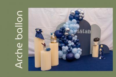 Arrangement floral avec des fleurs roses et blanches, entouré de petits sachets cadeaux en tissu et jute sur une table.