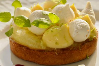 Miniature Traiteur Saint-Cloud (Hauts-de-Seine) - Aux Jardins des Sens #4 Façade illuminée d'un bâtiment élégant au crépuscule, avec un jardin et des invités rassemblés devant.