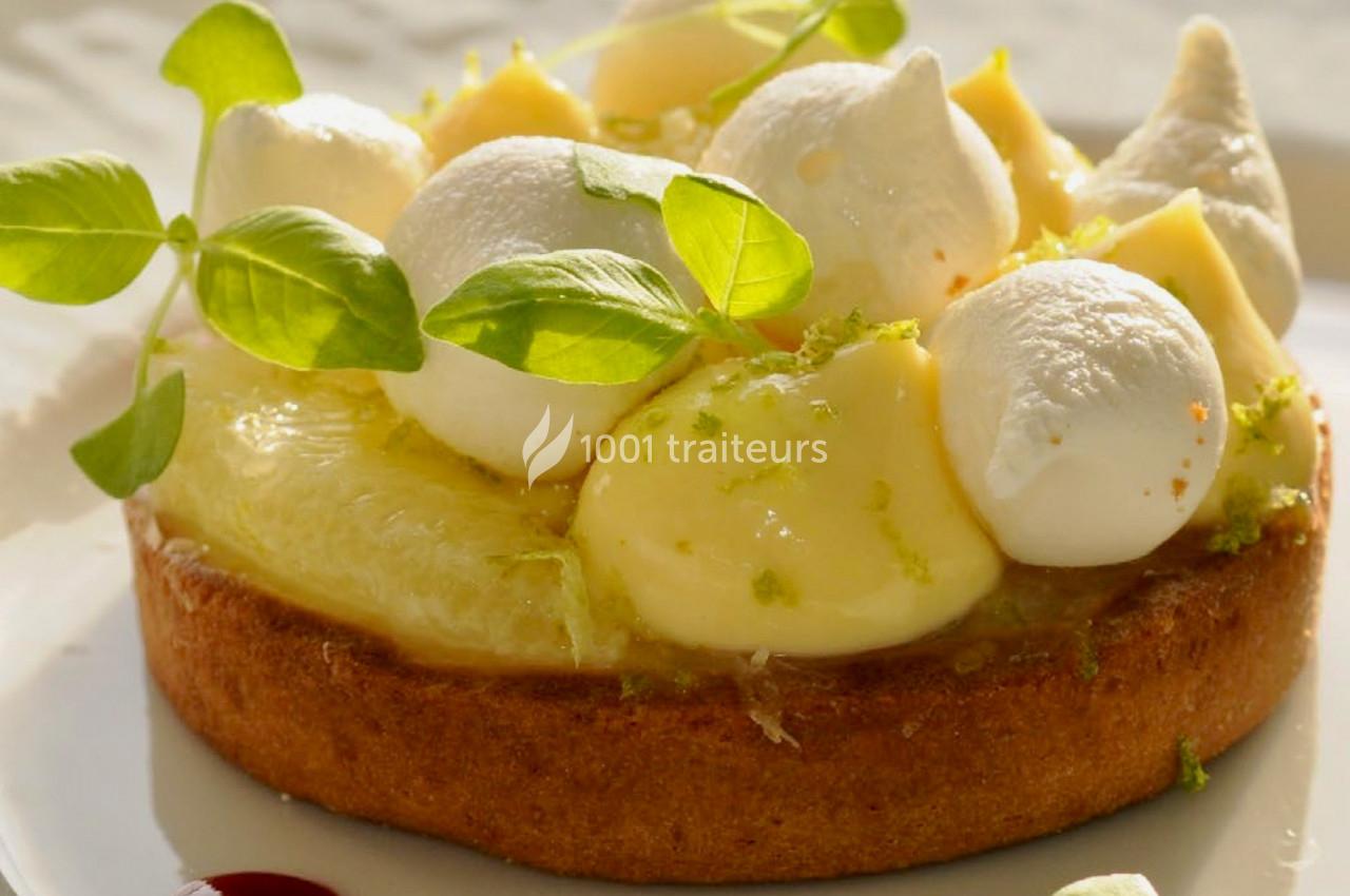 Tartelette garnie de crème citronnée, meringues légères, zestes de citron vert et décorée de feuilles fraîches.