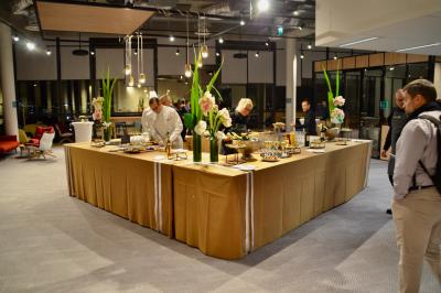 Miniature Traiteur Saint-Cloud (Hauts-de-Seine) - Aux Jardins des Sens #9 Façade illuminée d'un bâtiment élégant au crépuscule, avec un jardin et des invités rassemblés devant.