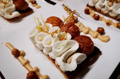 Miniature Traiteur Saint-Cloud (Hauts-de-Seine) - Aux Jardins des Sens #14 Façade illuminée d'un bâtiment élégant au crépuscule, avec un jardin et des invités rassemblés devant.