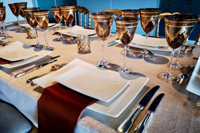 Miniature Traiteur Saint-Cloud (Hauts-de-Seine) - Aux Jardins des Sens #15 Façade illuminée d'un bâtiment élégant au crépuscule, avec un jardin et des invités rassemblés devant.