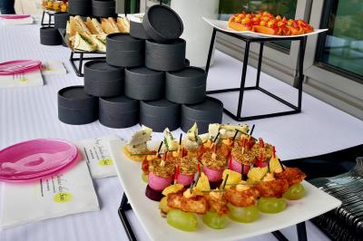 Miniature Traiteur Saint-Cloud (Hauts-de-Seine) - Aux Jardins des Sens #16 Façade illuminée d'un bâtiment élégant au crépuscule, avec un jardin et des invités rassemblés devant.