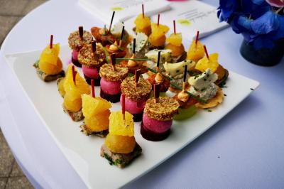 Miniature Traiteur Saint-Cloud (Hauts-de-Seine) - Aux Jardins des Sens #17 Façade illuminée d'un bâtiment élégant au crépuscule, avec un jardin et des invités rassemblés devant.