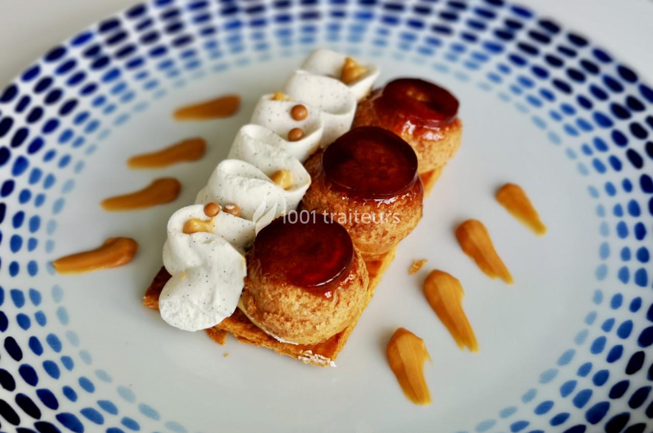 Dessert composé de choux caramélisés, chantilly vanillée et touches de caramel sur une assiette blanche décorée.