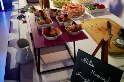 Miniature Traiteur Saint-Cloud (Hauts-de-Seine) - Aux Jardins des Sens #22 Façade illuminée d'un bâtiment élégant au crépuscule, avec un jardin et des invités rassemblés devant.