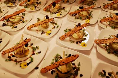 Miniature Traiteur Saint-Cloud (Hauts-de-Seine) - Aux Jardins des Sens #26 Façade illuminée d'un bâtiment élégant au crépuscule, avec un jardin et des invités rassemblés devant.