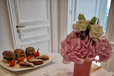 Miniature Traiteur Saint-Cloud (Hauts-de-Seine) - Aux Jardins des Sens #29 Façade illuminée d'un bâtiment élégant au crépuscule, avec un jardin et des invités rassemblés devant.