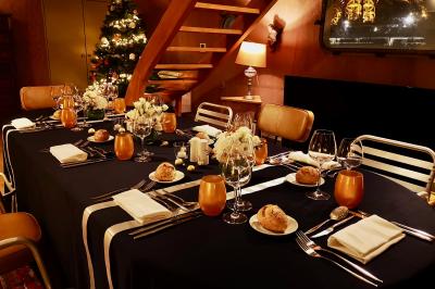 Miniature Traiteur Saint-Cloud (Hauts-de-Seine) - Aux Jardins des Sens #31 Façade illuminée d'un bâtiment élégant au crépuscule, avec un jardin et des invités rassemblés devant.