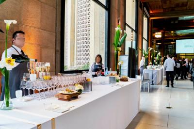 Miniature Traiteur Saint-Cloud (Hauts-de-Seine) - Aux Jardins des Sens #33 Façade illuminée d'un bâtiment élégant au crépuscule, avec un jardin et des invités rassemblés devant.