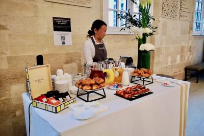 Miniature Traiteur Saint-Cloud (Hauts-de-Seine) - Aux Jardins des Sens #35 Façade illuminée d'un bâtiment élégant au crépuscule, avec un jardin et des invités rassemblés devant.