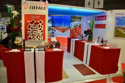 Miniature Traiteur Saint-Cloud (Hauts-de-Seine) - Aux Jardins des Sens #42 Façade illuminée d'un bâtiment élégant au crépuscule, avec un jardin et des invités rassemblés devant.