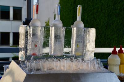 Miniature Traiteur Saint-Cloud (Hauts-de-Seine) - Aux Jardins des Sens #47 Façade illuminée d'un bâtiment élégant au crépuscule, avec un jardin et des invités rassemblés devant.