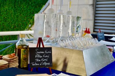 Miniature Traiteur Saint-Cloud (Hauts-de-Seine) - Aux Jardins des Sens #48 Façade illuminée d'un bâtiment élégant au crépuscule, avec un jardin et des invités rassemblés devant.