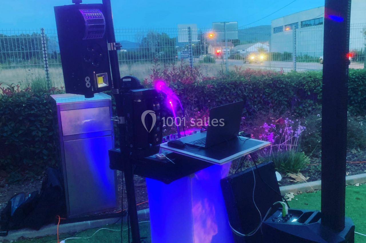 Équipement de sonorisation et éclairage installé en extérieur, comprenant un ordinateur portable et un micro.