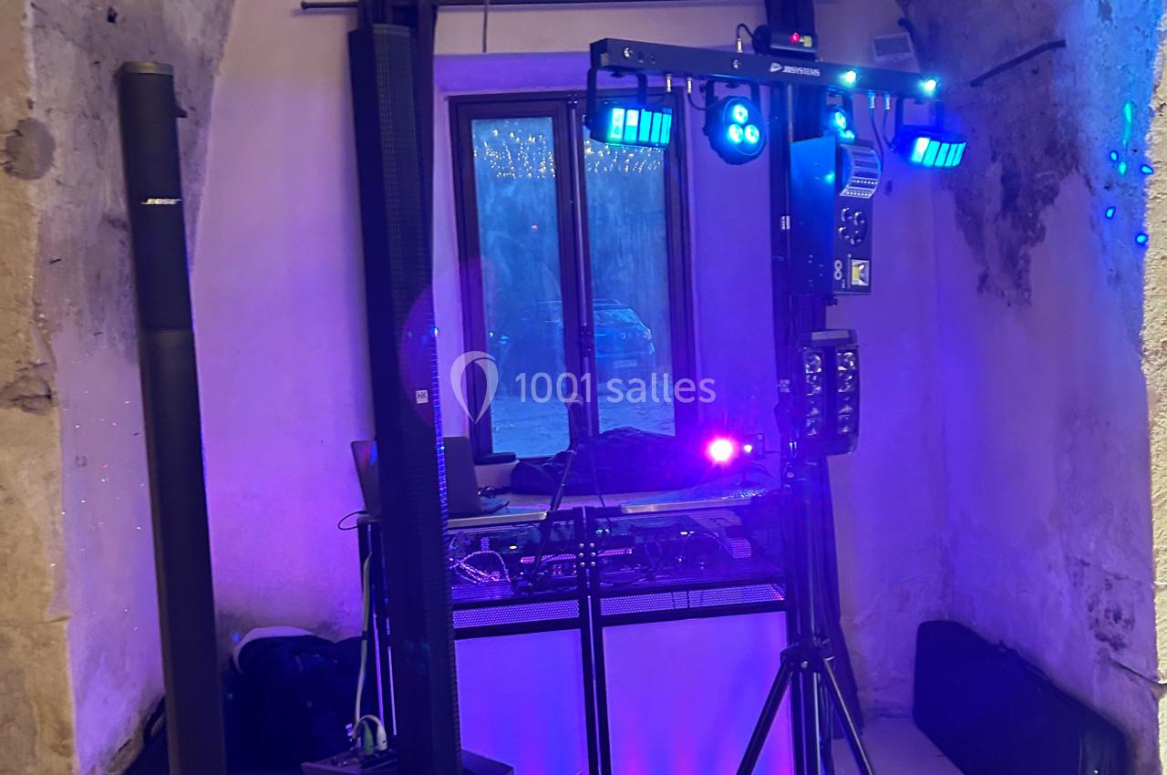 Équipement de sonorisation et éclairage installé dans une pièce en pierre avec une fenêtre donnant sur l'extérieur.