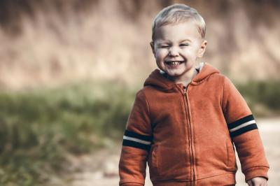 Clocher en pierre d'une église entouré de magnolias en fleurs sous un ciel bleu.