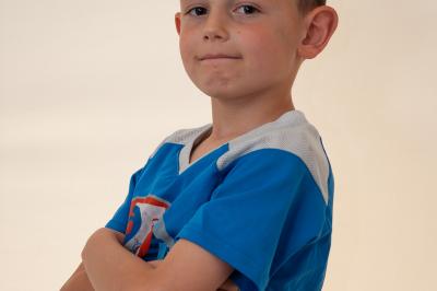 Clocher en pierre d'une église entouré de magnolias en fleurs sous un ciel bleu.