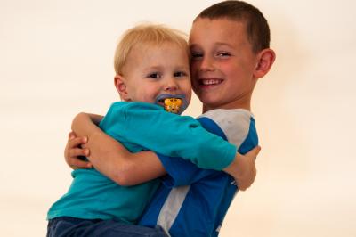 Clocher en pierre d'une église entouré de magnolias en fleurs sous un ciel bleu.