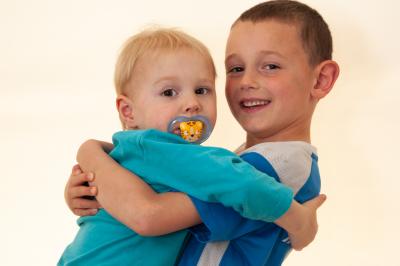 Clocher en pierre d'une église entouré de magnolias en fleurs sous un ciel bleu.