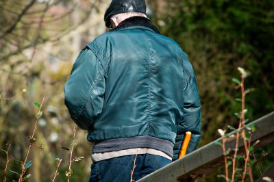 Un enfant souriant en t-shirt blanc pose avec une main sous le menton sur un fond clair.