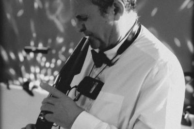 Miniature DJ Carcès (Var) - Dj Sax à Tout Coeur #8 Un homme en costume bleu tient un saxophone dans un intérieur lumineux avec de grandes fenêtres.