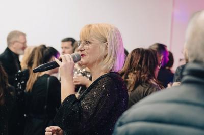 Miniature DJ Carcès (Var) - Dj Sax à Tout Coeur #11 Un homme en costume bleu tient un saxophone dans un intérieur lumineux avec de grandes fenêtres.